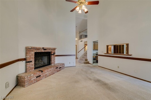 5505 Excelsior Springs Ln, Las Vegas, NV 89130 - unfurnished living room featuring carpet flooring, a ceiling fan, a high ceiling, stairway, and a fireplace