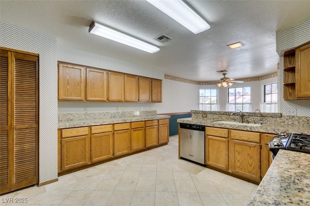 5505 Excelsior Springs Ln, Las Vegas, NV 89130 - kitchen with stainless steel dishwasher, black range with gas stovetop, a peninsula, brown cabinetry, and a textured ceiling