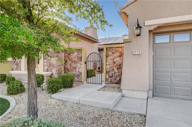 2172 De Rouge Ave, Henderson, NV 89044 - doorway to property with a gate, a tiled roof, stucco siding, stone siding, and a chimney