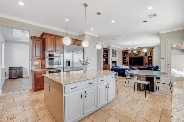 2172 De Rouge Ave, Henderson, NV 89044 - kitchen featuring appliances with stainless steel finishes, stone tile flooring, crown molding, pendant lighting, and a kitchen island