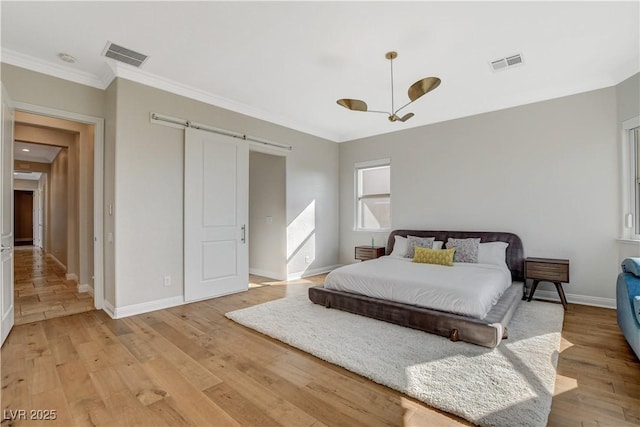 2172 De Rouge Ave, Henderson, NV 89044 - bedroom featuring a barn door, crown molding, and light wood-style flooring