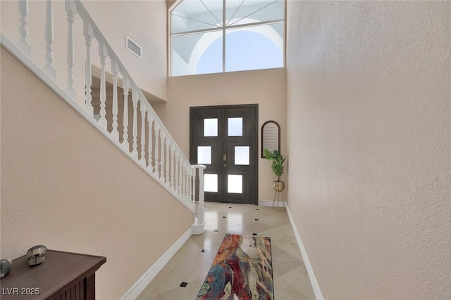 2209 Purple Majesty Ct, Las Vegas, NV 89117 - entrance foyer with plenty of natural light, a towering ceiling, stairs, and a textured wall