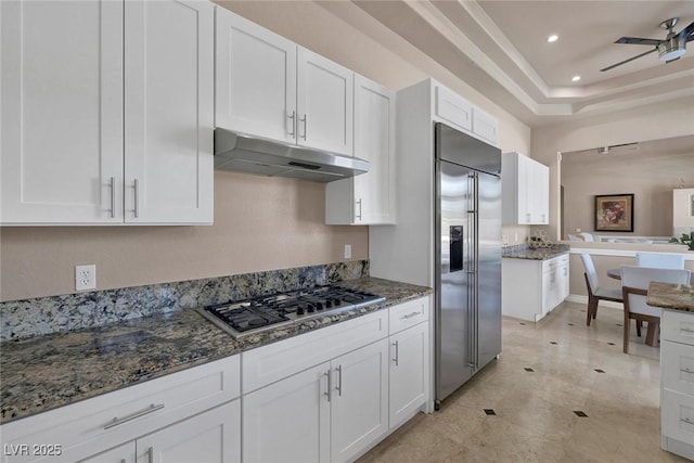 2209 Purple Majesty Ct, Las Vegas, NV 89117 - kitchen featuring stainless steel appliances, under cabinet range hood, ceiling fan, white cabinets, and dark stone counters