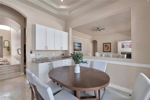 2209 Purple Majesty Ct, Las Vegas, NV 89117 - dining room featuring arched walkways, ceiling fan, recessed lighting, a raised ceiling, and light tile patterned floors