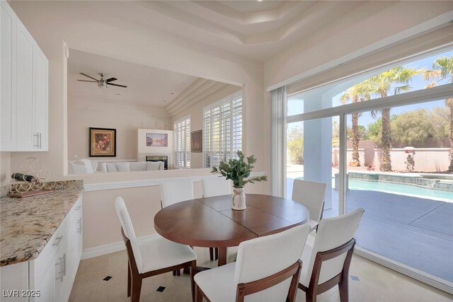 2209 Purple Majesty Ct, Las Vegas, NV 89117 - dining area with ceiling fan, light tile patterned floors, and a fireplace