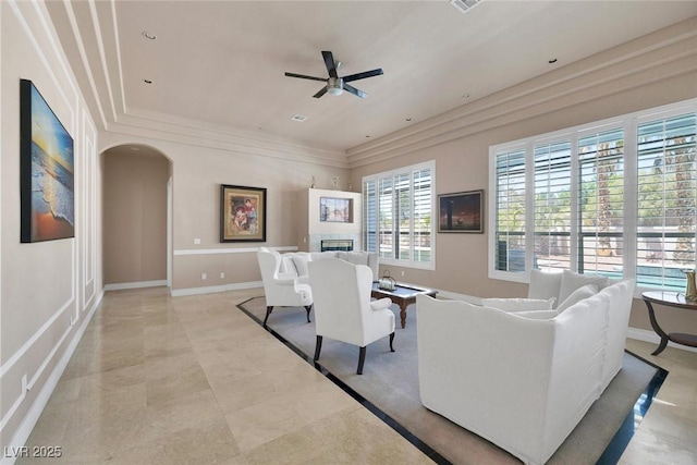 2209 Purple Majesty Ct, Las Vegas, NV 89117 - living room featuring a fireplace, a ceiling fan, arched walkways, and ornamental molding