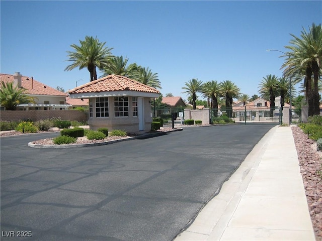 7955 Canto Ave, Las Vegas, NV 89147 - view of asphalt road featuring a gate, sidewalks, curbs, street lighting, and a gated entry