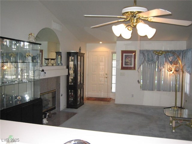 7955 Canto Ave, Las Vegas, NV 89147 - carpeted living area featuring a ceiling fan, a tiled fireplace, and arched walkways