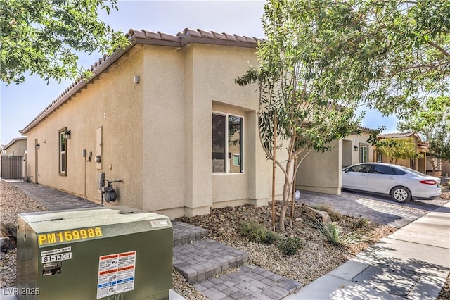 7472 Garnet Moon St, North Las Vegas, NV 89084 - view of side of property with stucco siding and a tiled roof