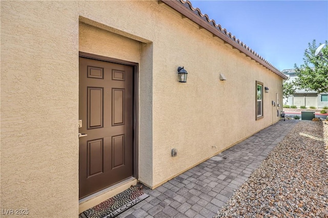 7472 Garnet Moon St, North Las Vegas, NV 89084 - view of exterior entry featuring stucco siding and a tile roof