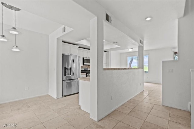 664 Peachy Canyon Cir Unit 103, Las Vegas, NV 89144 - kitchen featuring appliances with stainless steel finishes, light tile patterned floors, white cabinetry, light countertops, and decorative light fixtures