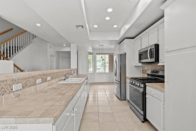 664 Peachy Canyon Cir Unit 103, Las Vegas, NV 89144 - kitchen featuring stainless steel appliances, backsplash, recessed lighting, white cabinetry, and a raised ceiling