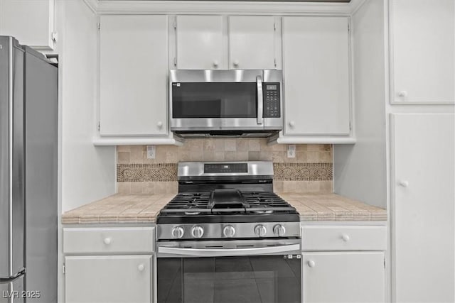 664 Peachy Canyon Cir Unit 103, Las Vegas, NV 89144 - kitchen with stainless steel appliances, white cabinets, and decorative backsplash