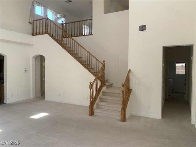 3328 White Bark Pine St, Las Vegas, NV 89129 - stairway featuring a high ceiling, arched walkways, and carpet flooring
