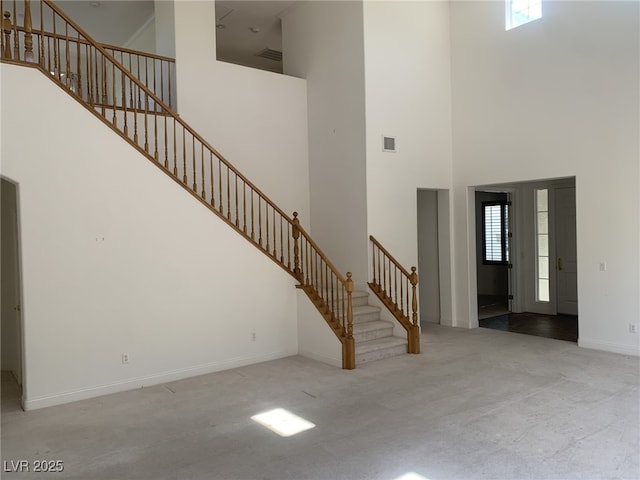 3328 White Bark Pine St, Las Vegas, NV 89129 - unfurnished living room featuring a towering ceiling, carpet, and stairway