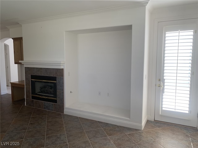 3328 White Bark Pine St, Las Vegas, NV 89129 - unfurnished living room with arched walkways, crown molding, a tile fireplace, and healthy amount of natural light