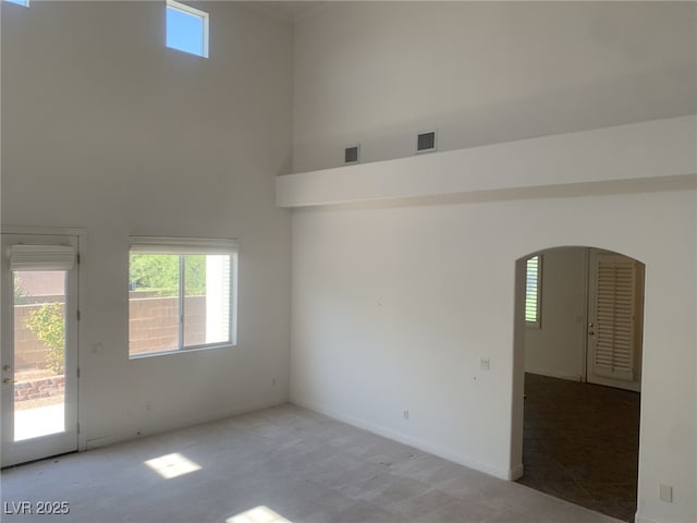 3328 White Bark Pine St, Las Vegas, NV 89129 - spare room with a high ceiling, arched walkways, carpet, and healthy amount of natural light