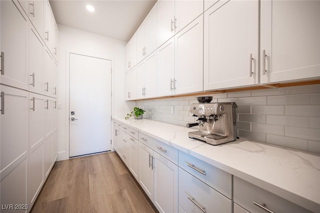 11248 Rebel Dome Ct, Las Vegas, NV 89141 - kitchen featuring backsplash, light wood-style floors, light stone countertops, white cabinetry, and recessed lighting