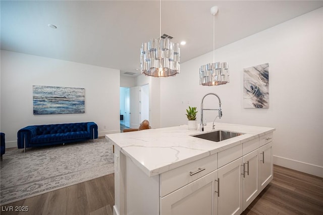 11248 Rebel Dome Ct, Las Vegas, NV 89141 - kitchen with dark wood finished floors, light stone counters, open floor plan, white cabinetry, and pendant lighting