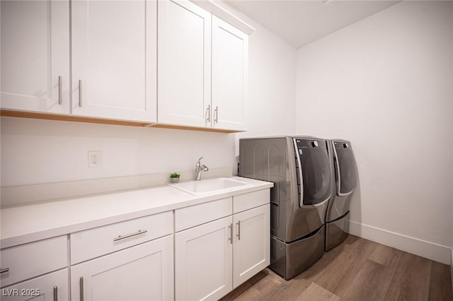 11248 Rebel Dome Ct, Las Vegas, NV 89141 - laundry area featuring washer and clothes dryer, light wood-style floors, and cabinet space