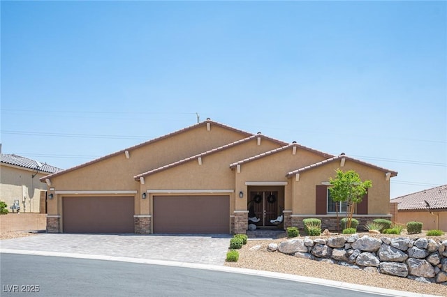 11248 Rebel Dome Ct, Las Vegas, NV 89141 - mediterranean / spanish house with stucco siding, stone siding, a garage, and decorative driveway