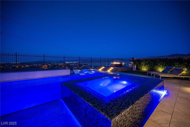11248 Rebel Dome Ct, Las Vegas, NV 89141 - pool at night featuring a pool with connected hot tub