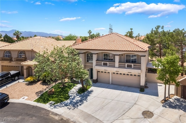 1403 Graystone Canyon Ave, Las Vegas, NV 89183 - mediterranean / spanish home with an attached garage, a tiled roof, stucco siding, concrete driveway, and a balcony