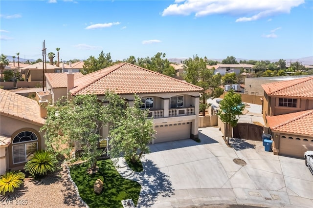 1403 Graystone Canyon Ave, Las Vegas, NV 89183 - mediterranean / spanish house with stucco siding, concrete driveway, a garage, a tiled roof, and a residential view