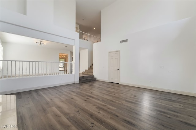 1403 Graystone Canyon Ave, Las Vegas, NV 89183 - unfurnished living room with a towering ceiling, wood finished floors, and stairway