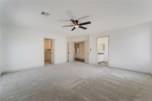 1403 Graystone Canyon Ave, Las Vegas, NV 89183 - unfurnished bedroom featuring light colored carpet, a spacious closet, connected bathroom, and a ceiling fan