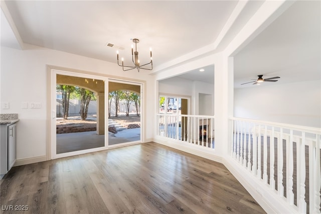 1403 Graystone Canyon Ave, Las Vegas, NV 89183 - unfurnished dining area featuring a chandelier, wood finished floors, and a ceiling fan