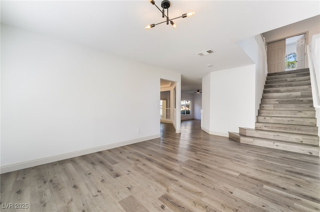 1403 Graystone Canyon Ave, Las Vegas, NV 89183 - unfurnished living room with a chandelier, wood finished floors, and stairway
