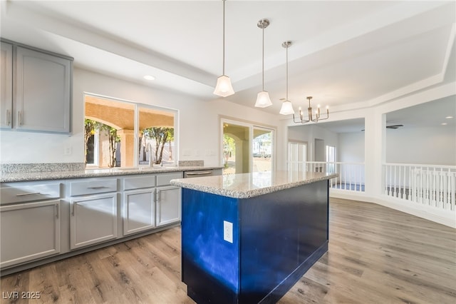 1403 Graystone Canyon Ave, Las Vegas, NV 89183 - kitchen featuring a tray ceiling, light wood-type flooring, decorative light fixtures, a chandelier, and recessed lighting