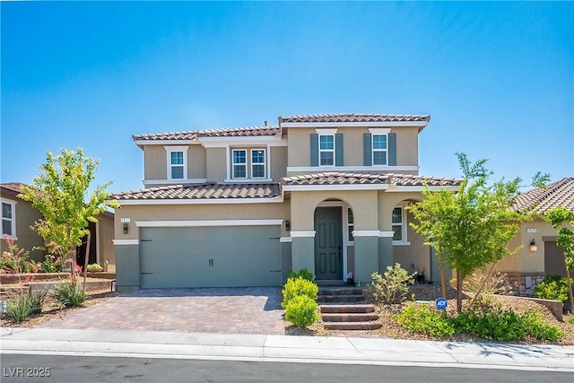 2577 Tolmezzo St, Henderson, NV 89044 - mediterranean / spanish home featuring a garage, driveway, stucco siding, and a tiled roof