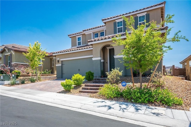 2577 Tolmezzo St, Henderson, NV 89044 - mediterranean / spanish-style home with stucco siding, a tile roof, and driveway