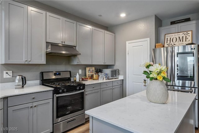 2577 Tolmezzo St, Henderson, NV 89044 - kitchen with stainless steel appliances, gray cabinetry, under cabinet range hood, a center island, and recessed lighting