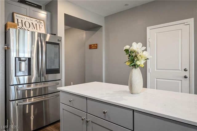 2577 Tolmezzo St, Henderson, NV 89044 - kitchen featuring stainless steel fridge, gray cabinets, light countertops, and dark wood-style flooring