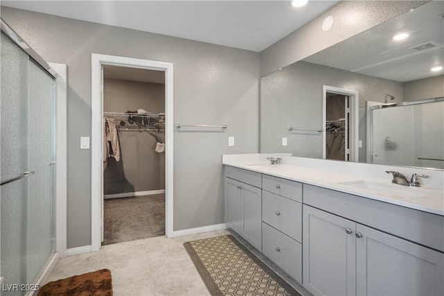 2577 Tolmezzo St, Henderson, NV 89044 - bathroom with a walk in closet, a stall shower, double vanity, and recessed lighting