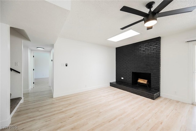 716 Vincent Way, Las Vegas, NV 89145 - unfurnished living room with ceiling fan, a textured ceiling, wood finished floors, a brick fireplace, and stairs