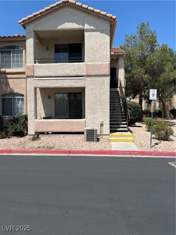 1830 N Buffalo Dr Unit 2021, Las Vegas, NV 89128 - view of front of house with a tiled roof, a balcony, stucco siding, and stairs