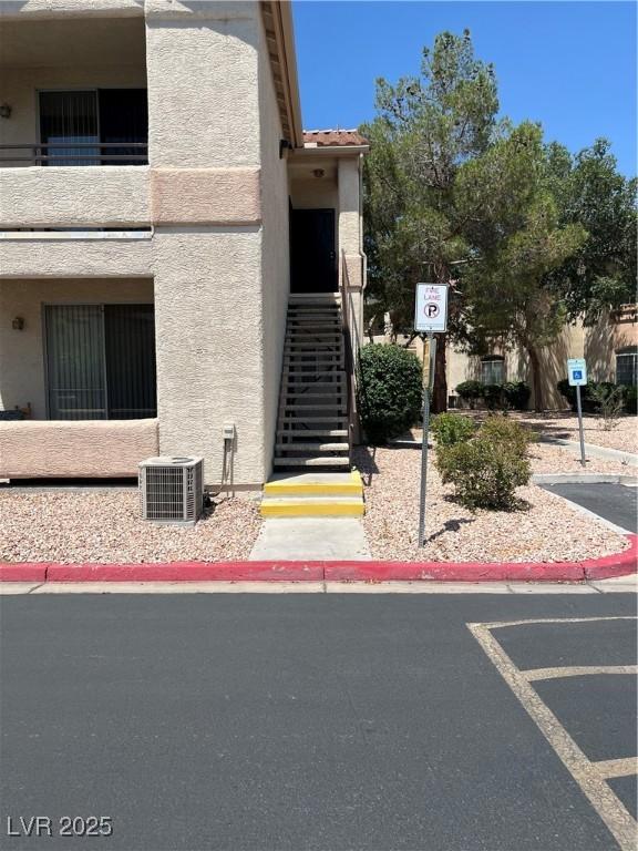 1830 N Buffalo Dr Unit 2021, Las Vegas, NV 89128 - view of building exterior featuring stairs and uncovered parking