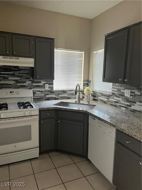 1830 N Buffalo Dr Unit 2021, Las Vegas, NV 89128 - kitchen with white appliances, under cabinet range hood, tasteful backsplash, and light tile patterned flooring