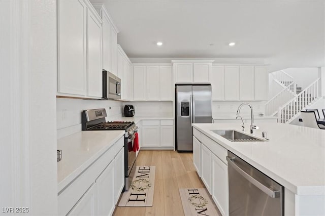 9221 Alden Pointe Ct, Las Vegas, NV 89143 - kitchen featuring stainless steel appliances, light wood finished floors, white cabinets, recessed lighting, and light countertops
