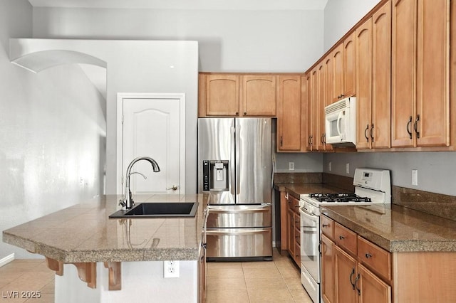 9105 Picket Fence Ave, Las Vegas, NV 89143 - kitchen featuring white appliances, tile counters, light tile patterned flooring, an island with sink, and a kitchen breakfast bar