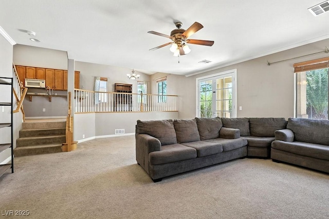 9105 Picket Fence Ave, Las Vegas, NV 89143 - living area with light carpet, a ceiling fan, a chandelier, ornamental molding, and stairs