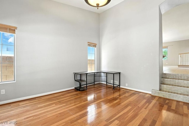 9105 Picket Fence Ave, Las Vegas, NV 89143 - empty room featuring wood-type flooring, stairs, and a towering ceiling