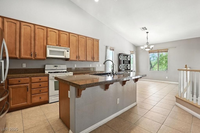 9105 Picket Fence Ave, Las Vegas, NV 89143 - kitchen featuring white appliances, brown cabinets, light tile patterned floors, a kitchen bar, and high vaulted ceiling