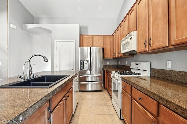 9105 Picket Fence Ave, Las Vegas, NV 89143 - kitchen with white appliances, brown cabinets, and light tile patterned floors