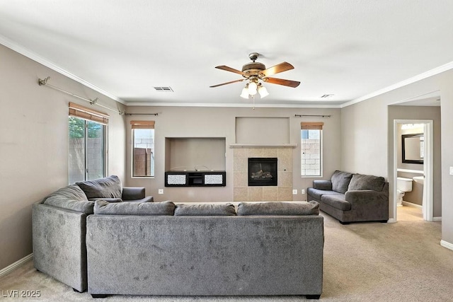 9105 Picket Fence Ave, Las Vegas, NV 89143 - living room featuring healthy amount of natural light, a ceiling fan, light colored carpet, a tiled fireplace, and ornamental molding
