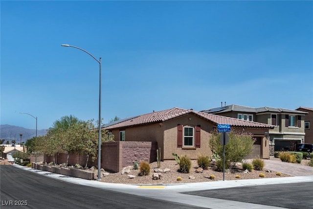 3012 Chiefs Ct, North Las Vegas, NV 89032 - view of asphalt street with street lighting, a mountain view, and curbs